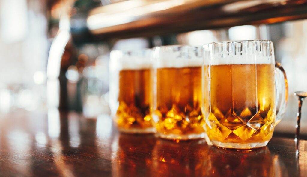 Bicchieri di birra chiara su un bancone di un pub scuro